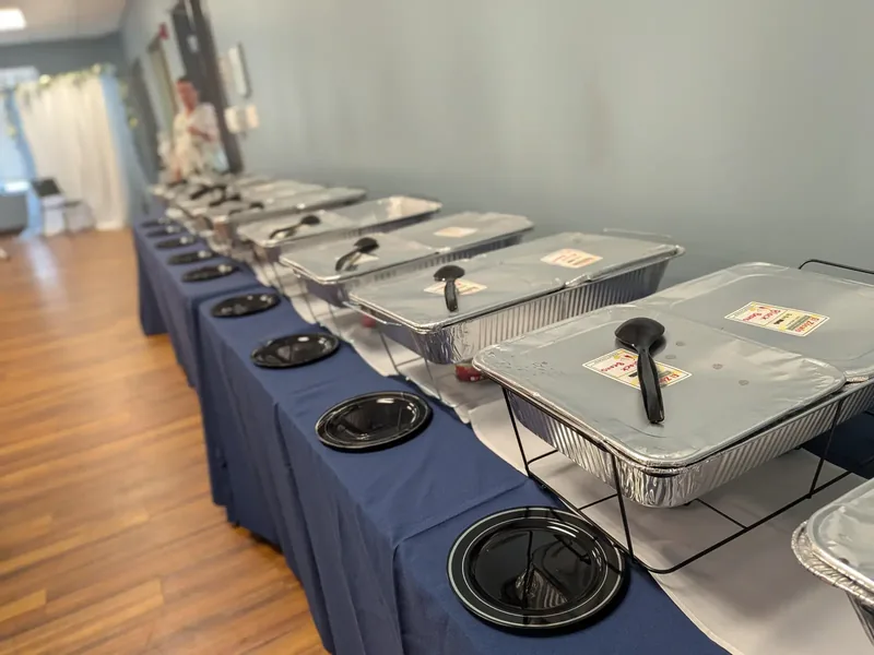 A real Silver Platter Logistics buffet setup with covered catering trays and serving pieces
